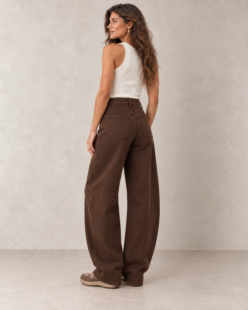 Jean barrel marron porté de dos par le mannequin Le Coin Sauvage sur fond beige