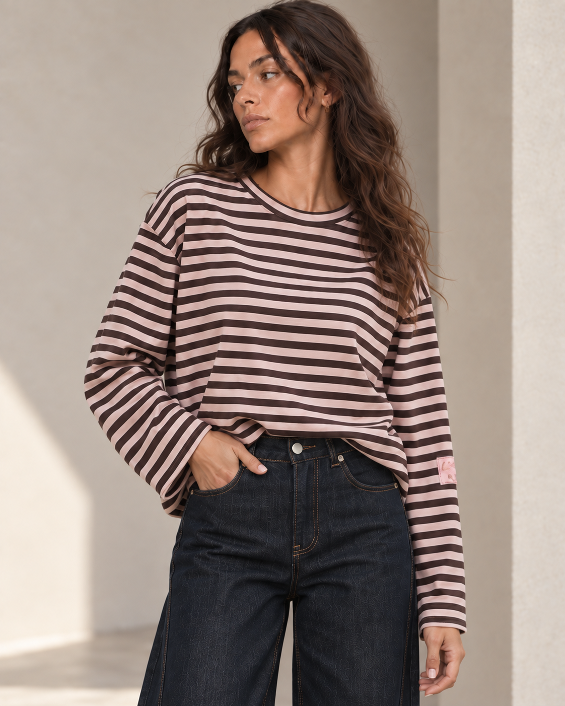 Détail de la marinière oversize rose poudré et chocolat sur mannequin brune