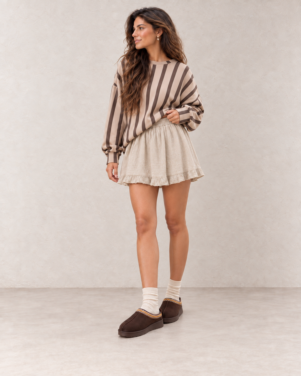 Mules fourrées chocolat portées avec une jupe en gaze de coton beige naturel