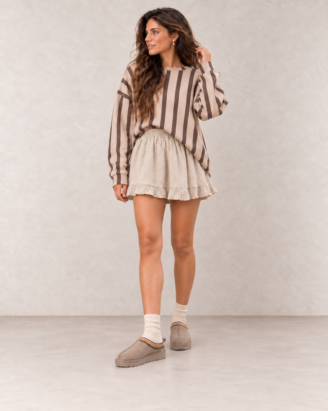 Mules fourrées taupe portées avec une jupe en gaze de coton beige naturel