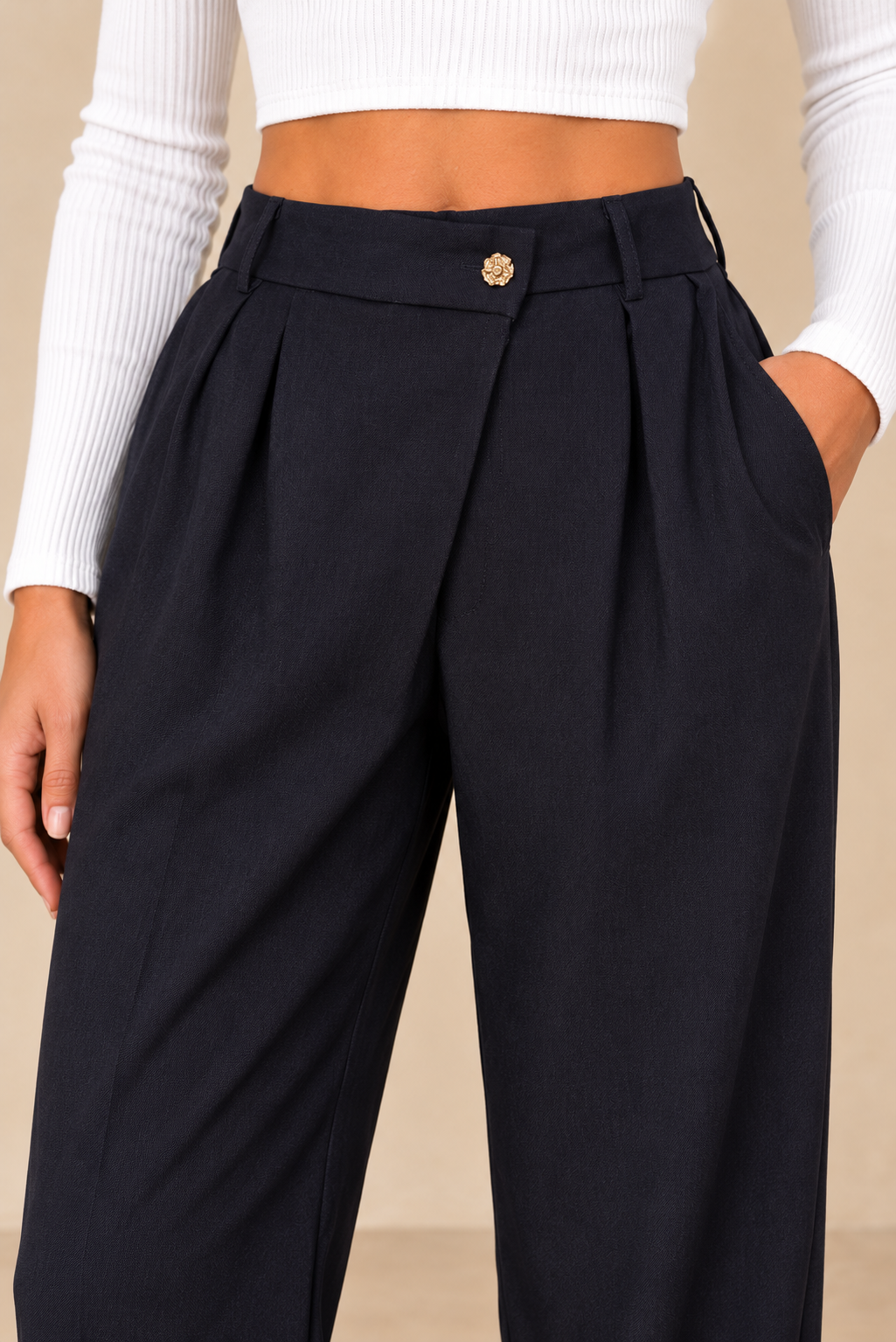 Pantalon à pinces marine – détail de la taille et du bouton doré