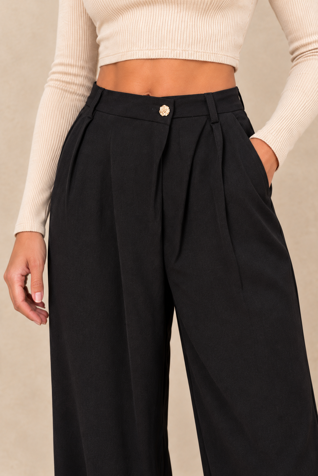 Pantalon à pinces noir – détail de la taille et du bouton doré