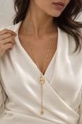 Sautoir doré en acier inoxydable avec pendentifs maille marine porté sur une blouse blanche