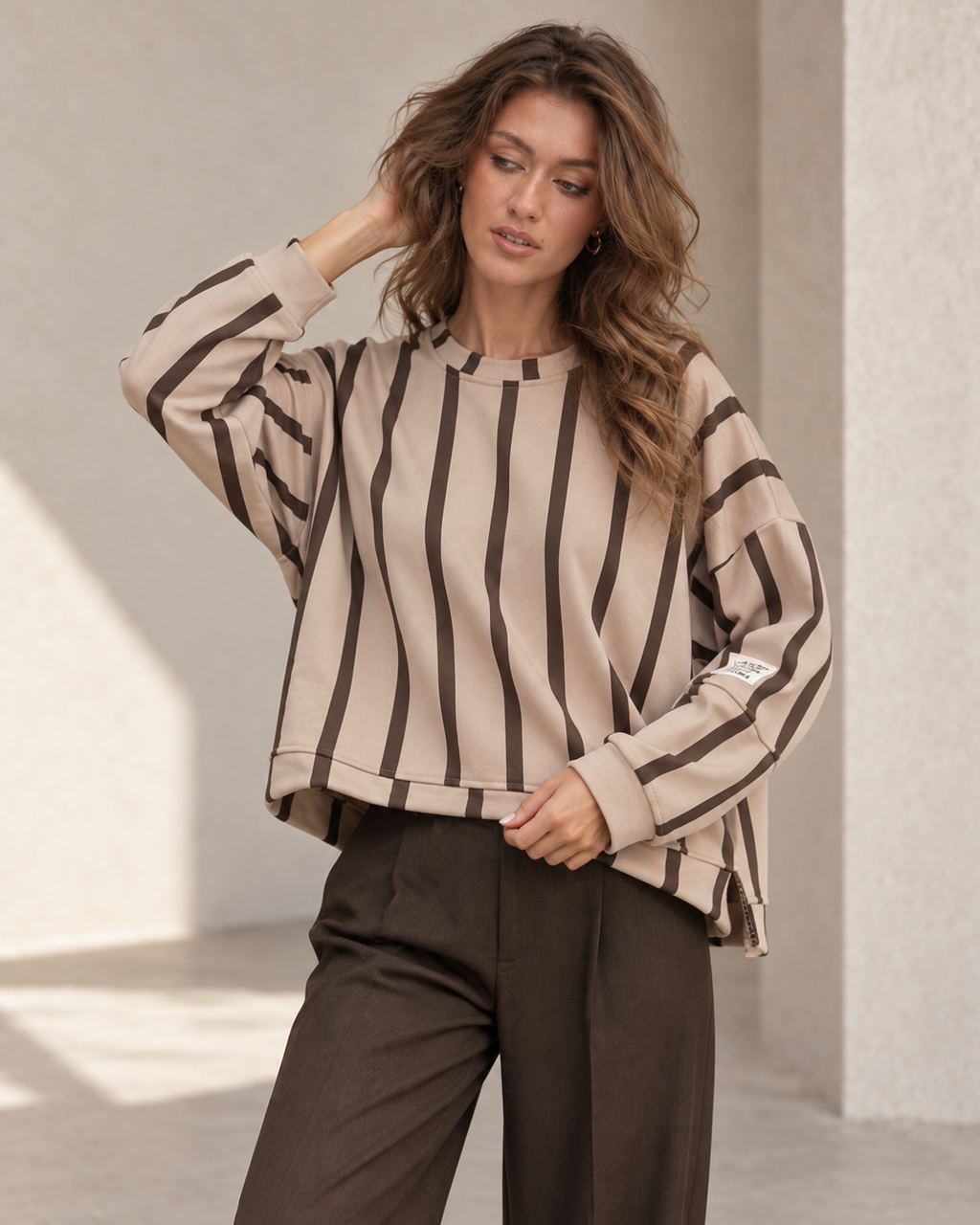 Détail du sweat oversize beige et chocolat, coupe asymétrique