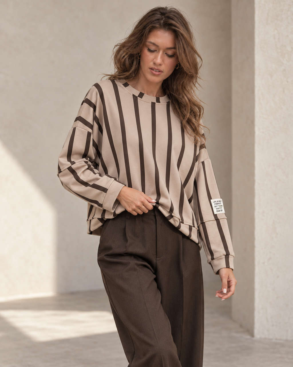 Sweat oversize beige rayé chocolat porté par le mannequin Le Coin Sauvage