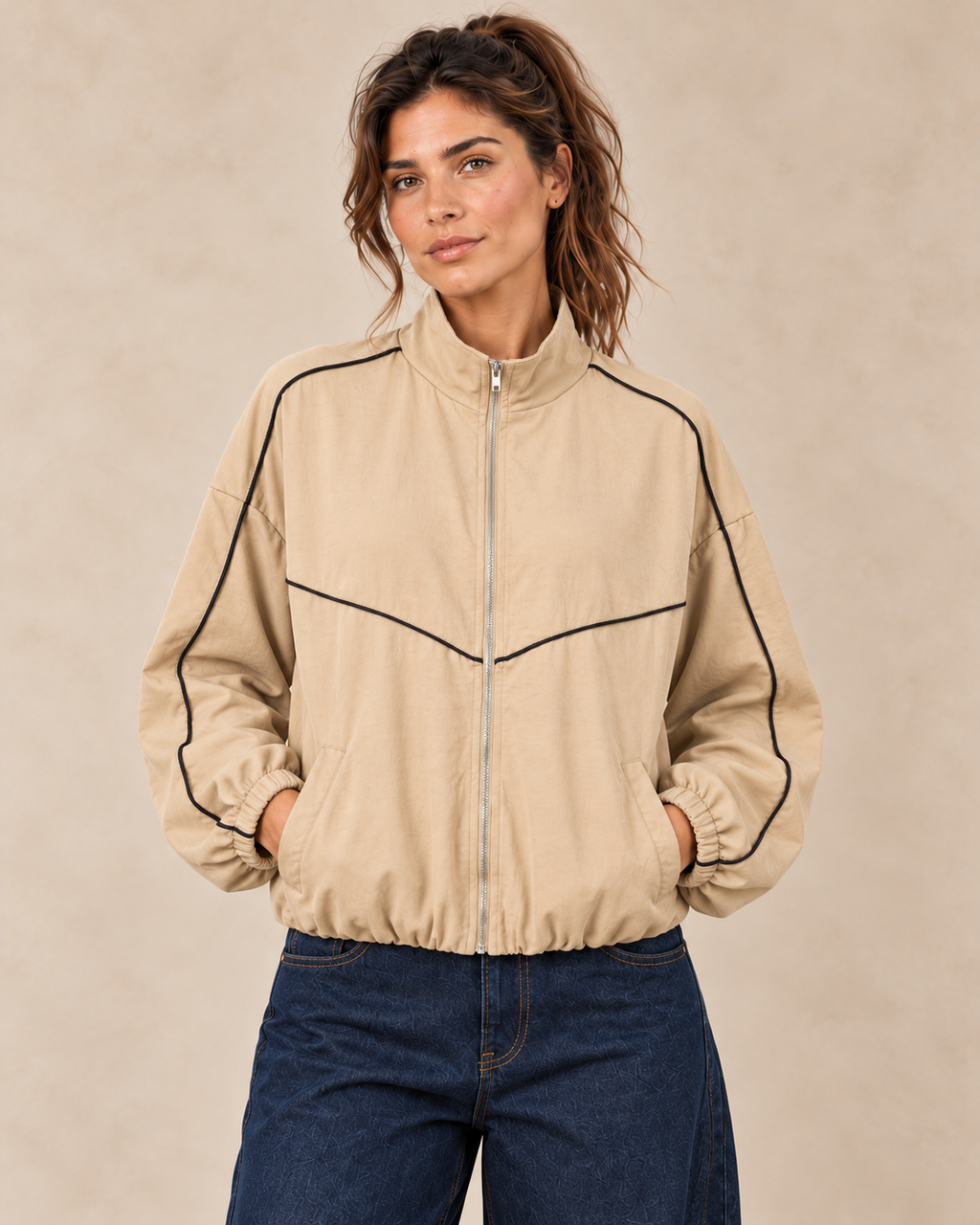 Veste beige à passepoils noirs, col montant et bas élastiqué — vue rapprochée