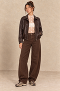 Veste en simili-cuir chocolat portée avec dentelle écrue et jean barrel marron