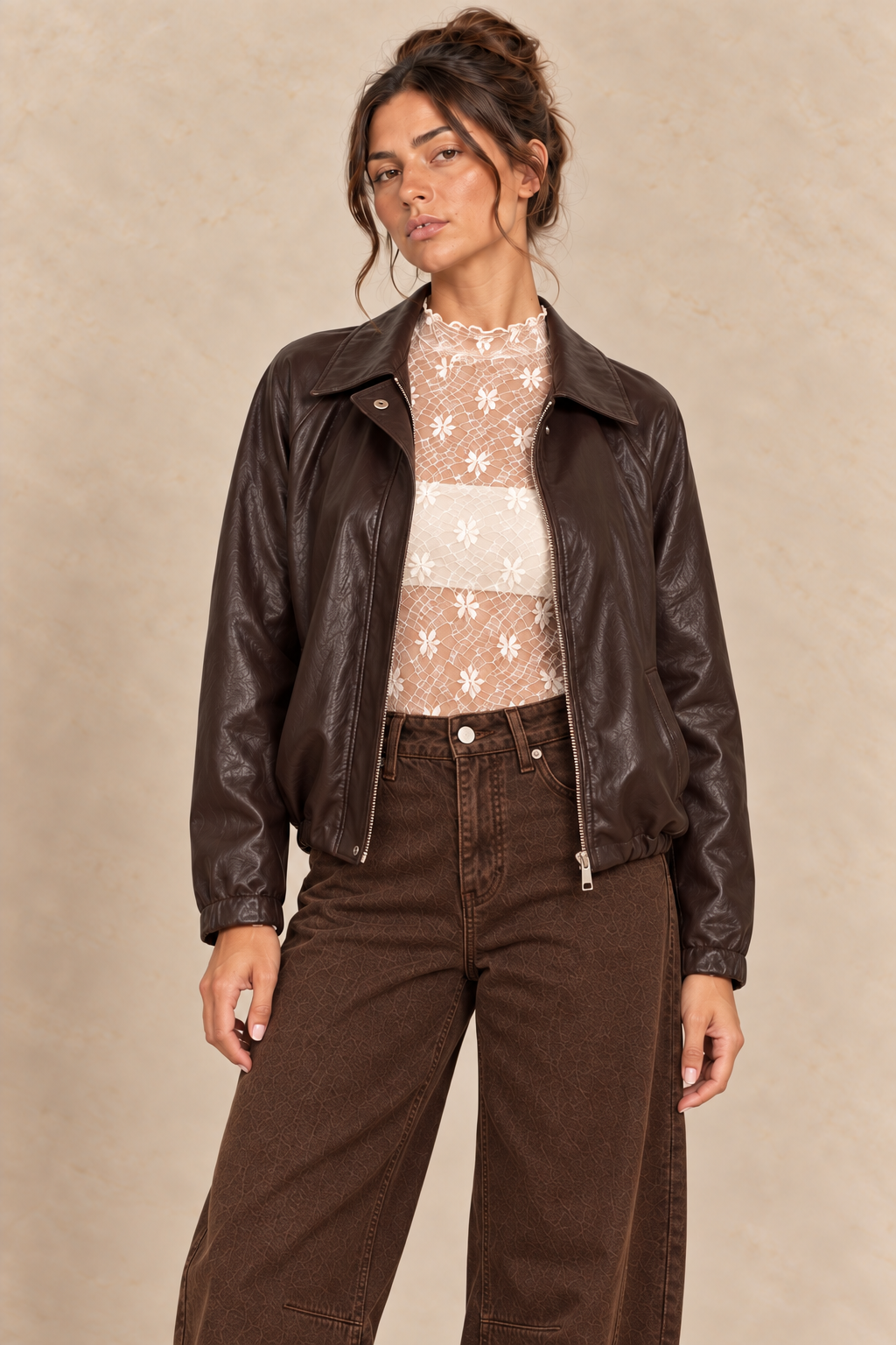 Veste en simili-cuir chocolat portée avec dentelle écrue et jean barrel marron