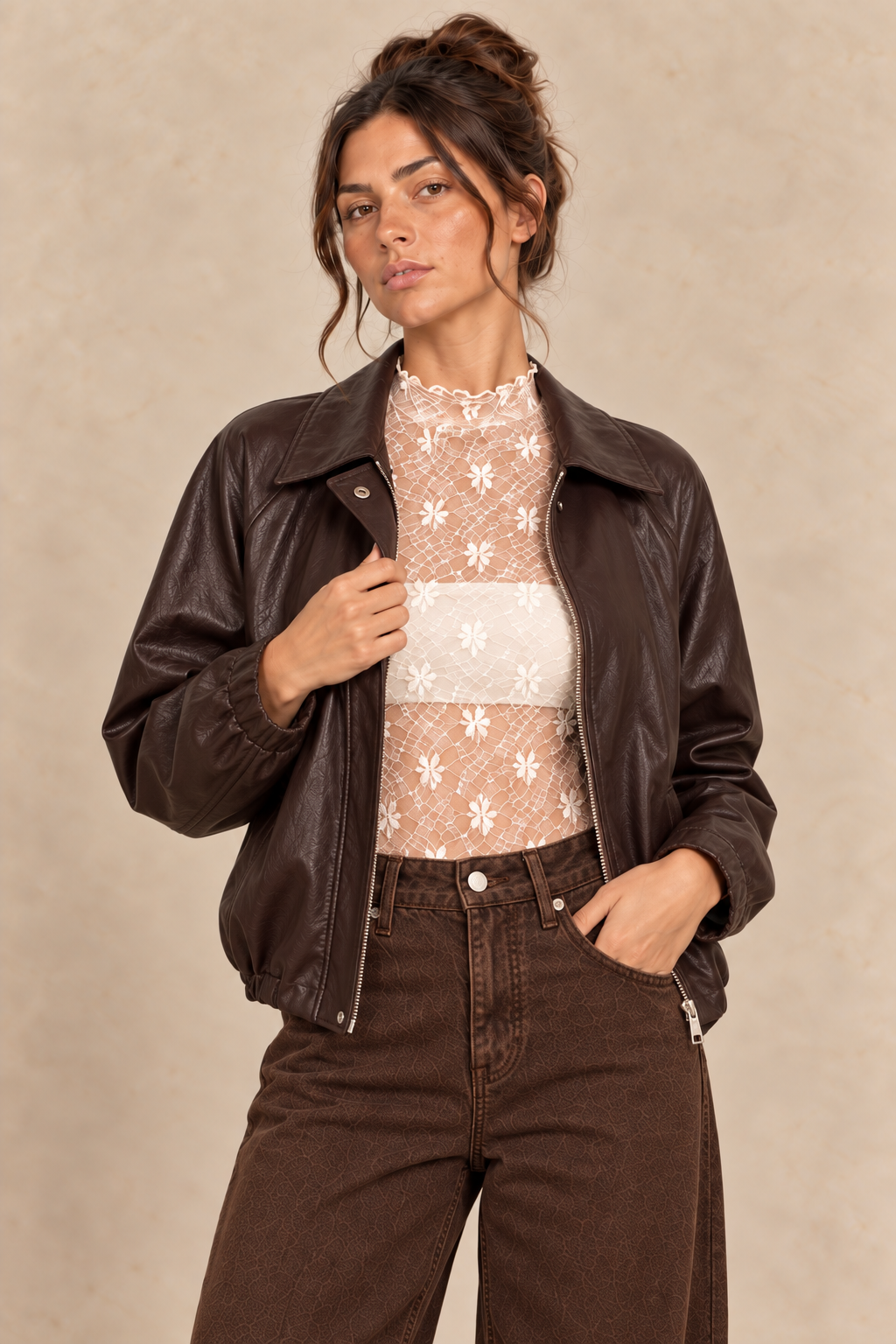 Veste en simili-cuir chocolat portée avec dentelle écrue et jean barrel marron